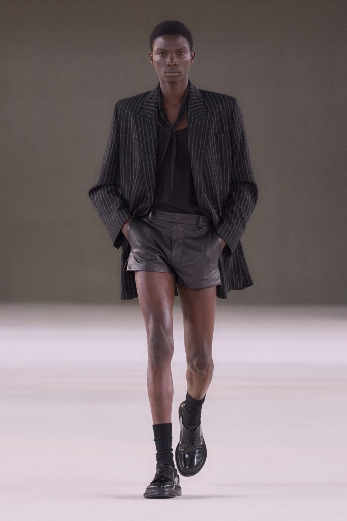 A fitted black striped blazer paired with leather shorts for a modern look.