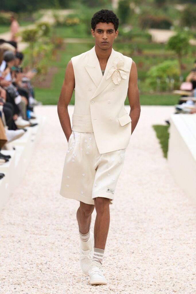 A fitted white sleeveless vest with embroidered details paired with matching shorts.