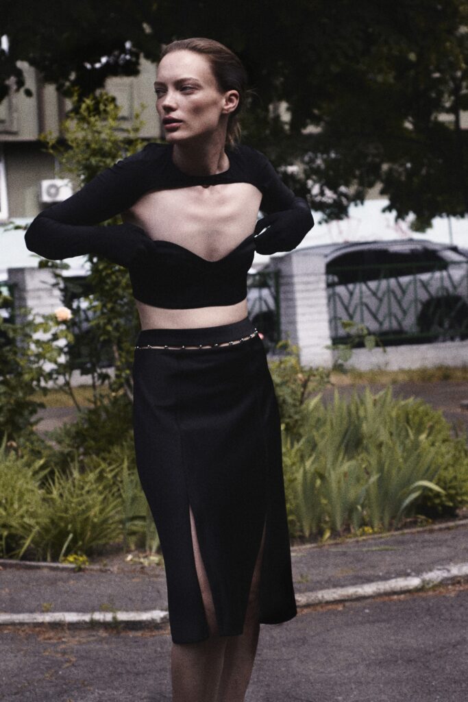 A fitted black sleeveless top paired with a pencil skirt featuring a slit detail.