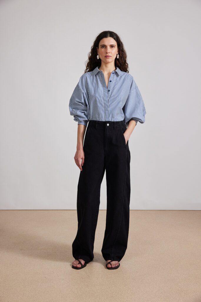 A relaxed blue striped long-sleeve shirt paired with wide-leg black pants.