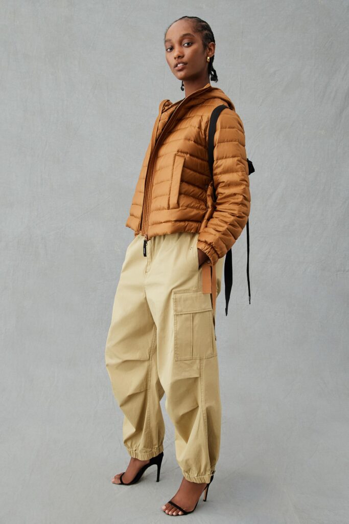 A relaxed brown jacket with a collar paired with beige pants featuring a zippered detail.