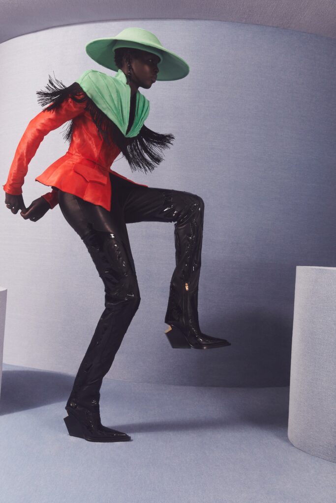 A fitted red leather jacket with fringes paired with sleek black leather pants.