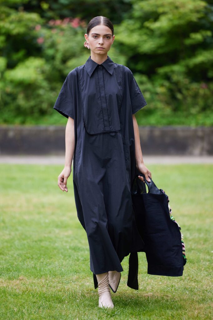 An oversized black cotton dress with a collared neckline and a relaxed fit.