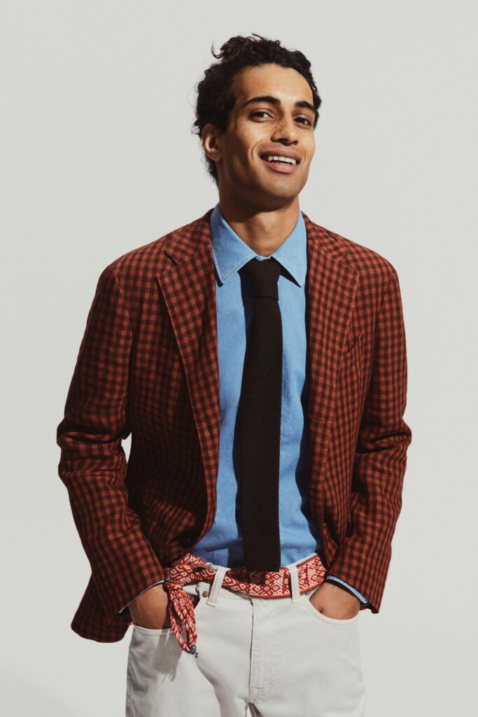 A fitted brown checked blazer paired with a blue collared shirt.