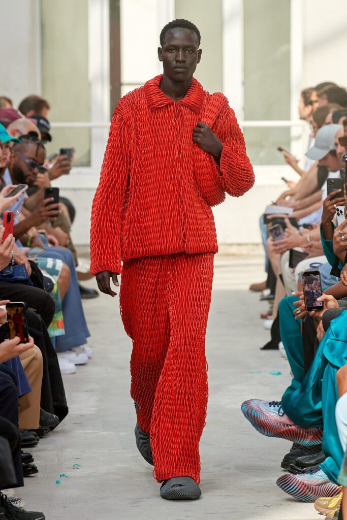 A relaxed red cotton jacket with long sleeves paired with matching pants featuring a layered design.