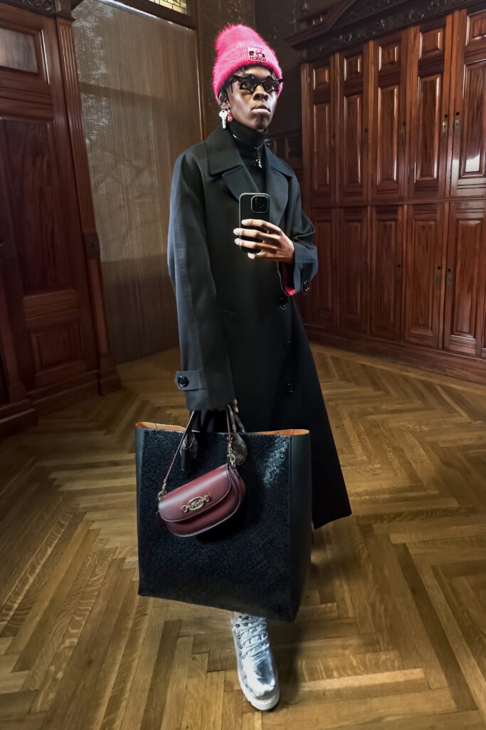An oversized black wool coat with long sleeves and a collared design, featuring button details.