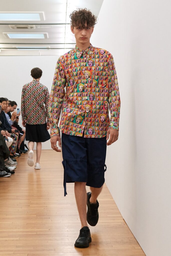A relaxed-fit multicolor printed shirt paired with navy shorts, featuring a collared design.