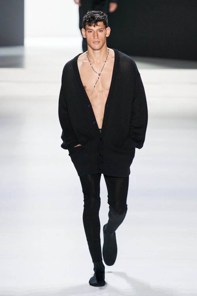 A relaxed black cardigan with a V-neckline paired with black leggings.