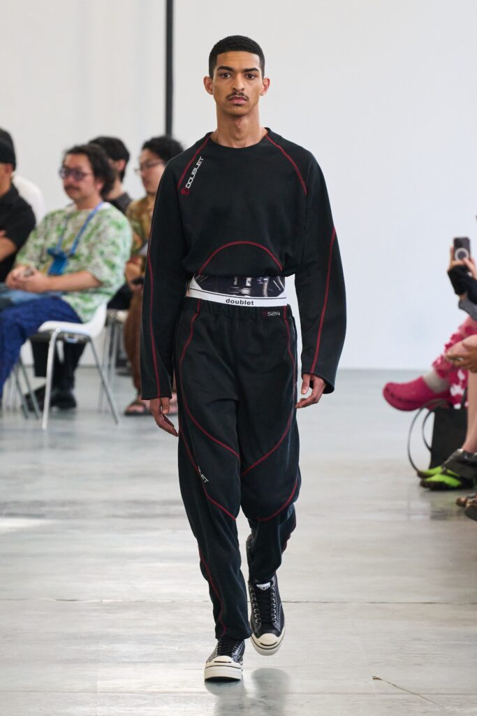 A relaxed black long-sleeve top with matching pants featuring striped details.