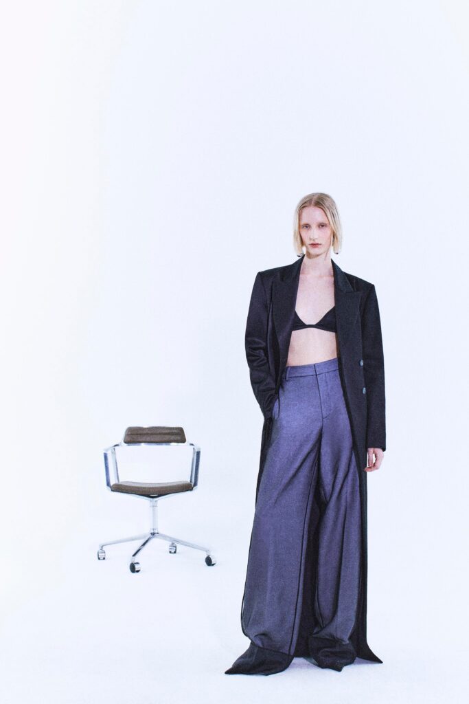 A relaxed black coat paired with high-waisted gray pants featuring a wide-leg silhouette.