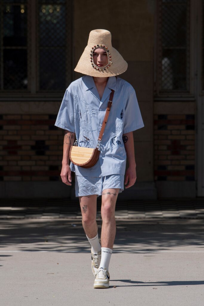 A relaxed blue cotton romper with short sleeves and embroidered details.