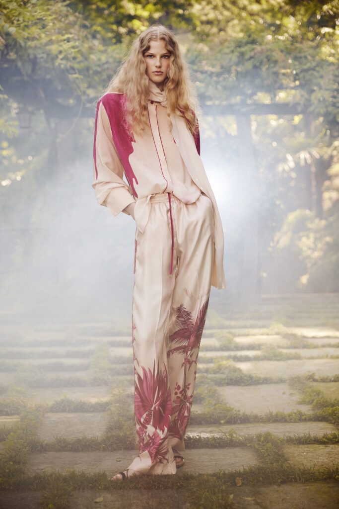 A relaxed fit beige silk shirt with long sleeves and printed pants featuring red floral designs.