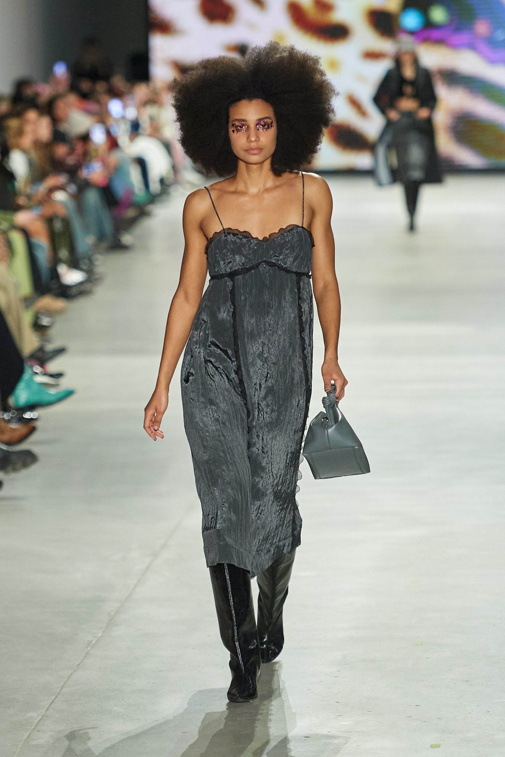 A relaxed black silk sleeveless dress with a V-neckline and straight-leg silhouette.