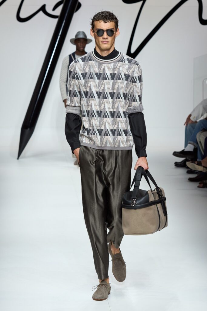 A relaxed fit printed black long-sleeve top paired with wide-leg gray pants.