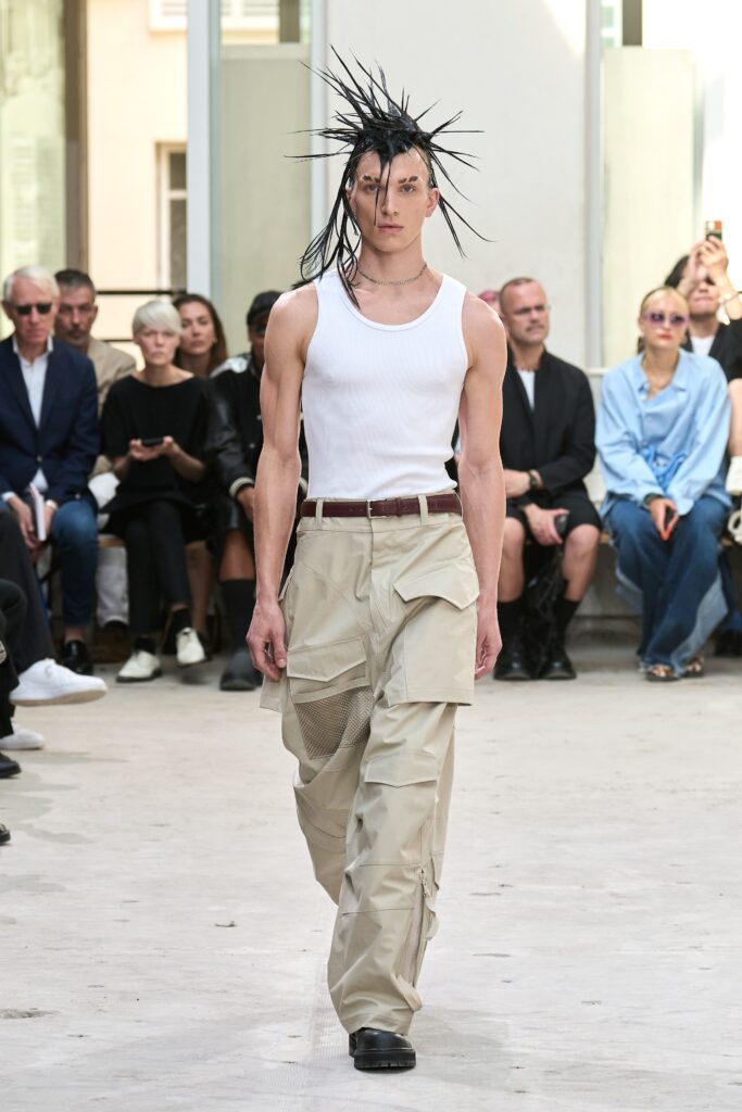A relaxed outfit featuring beige pants and a sleeveless white top.