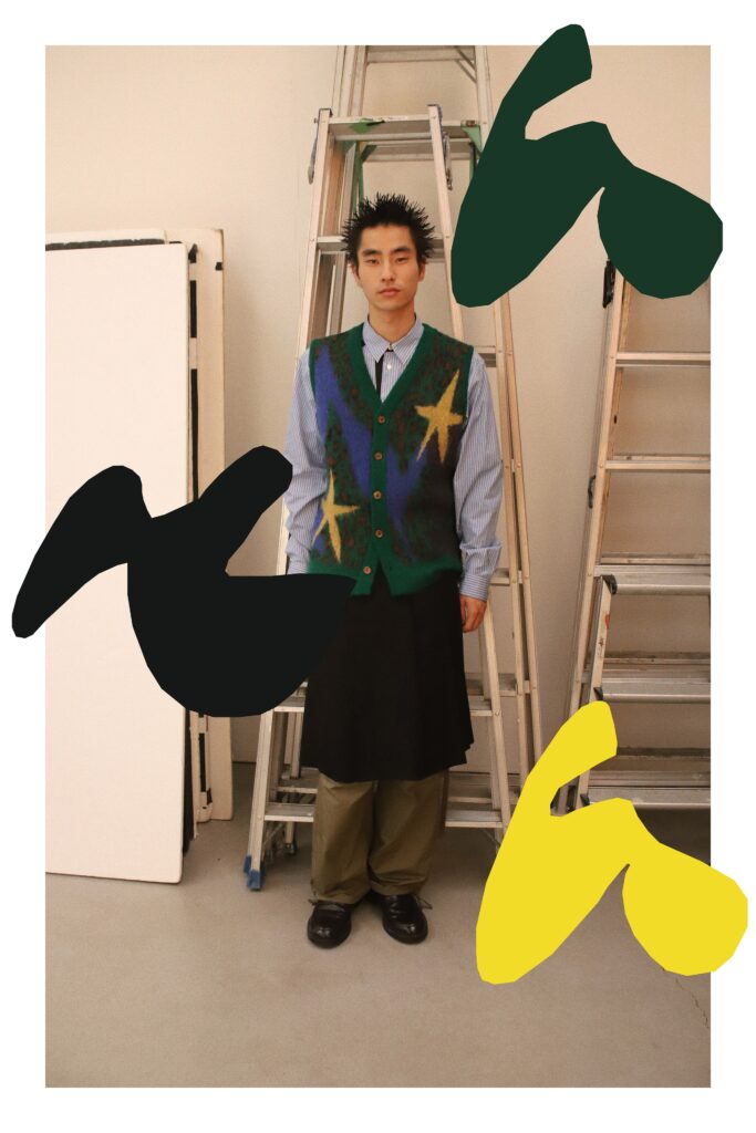 An oversized green vest layered over a blue shirt, paired with a black skirt.