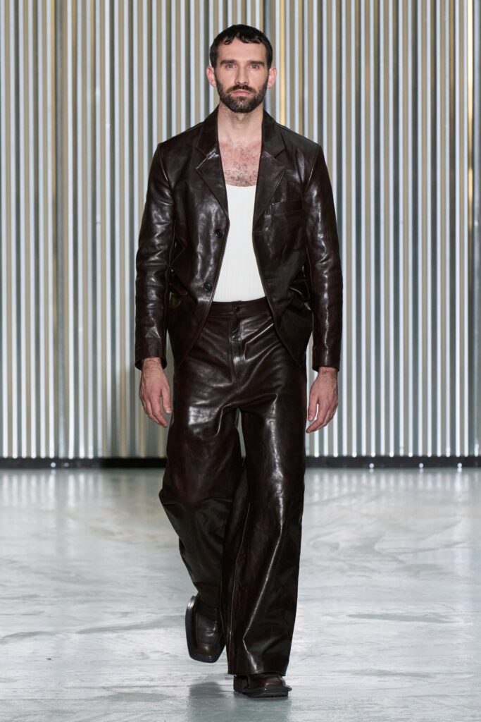 A fitted brown leather jacket paired with matching straight-leg pants, featuring a collared design.