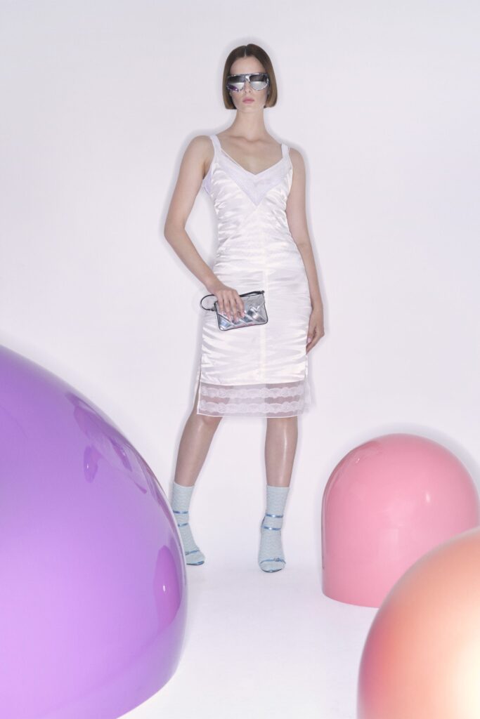 A fitted white silk dress with a sleeveless design and V-neckline.