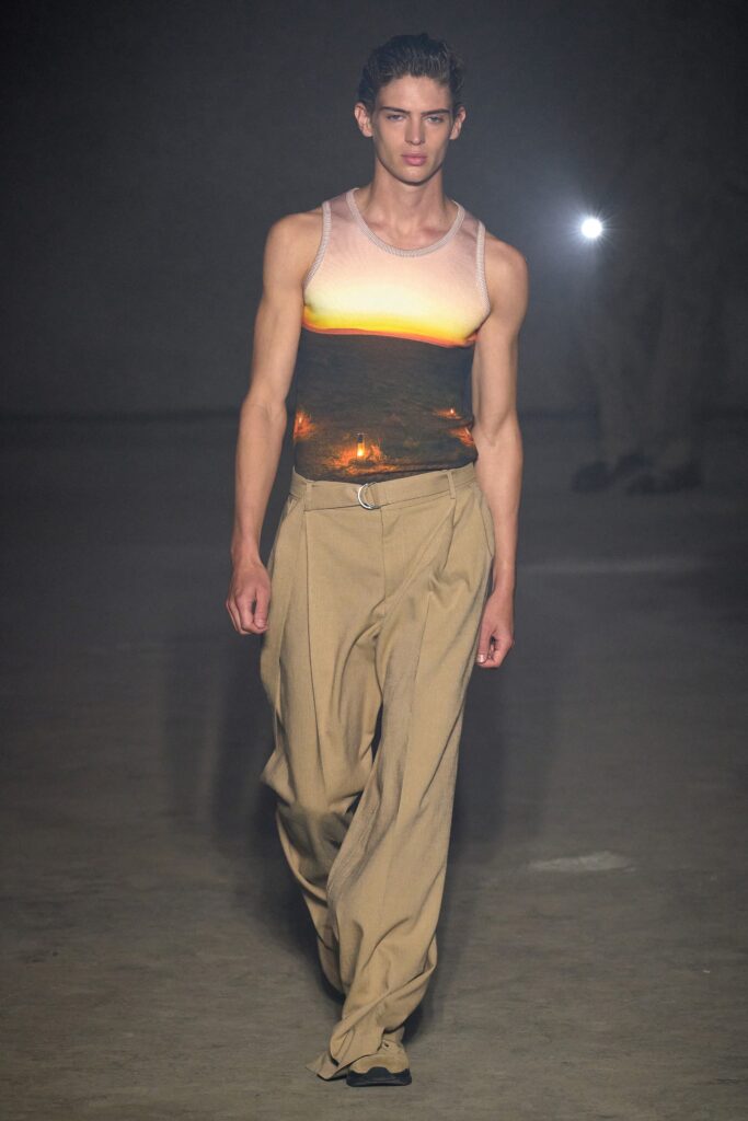 A relaxed beige printed sleeveless top paired with loose-fitting pants.