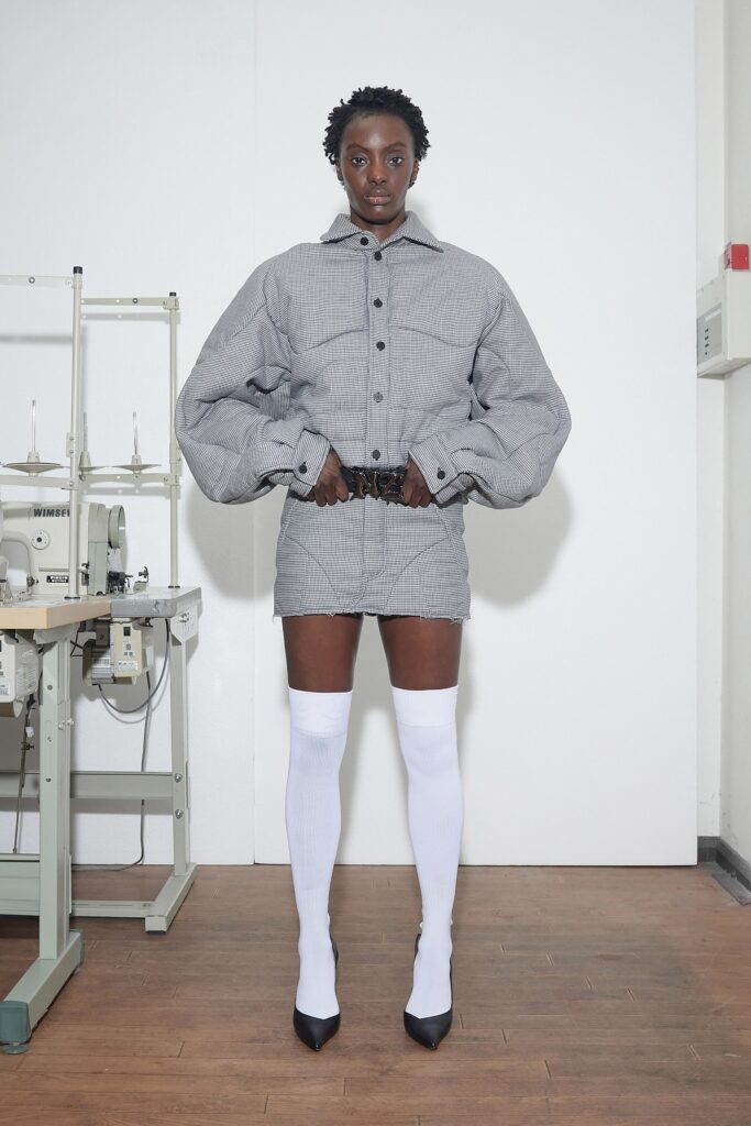 A fitted gray cotton jacket with long sleeves and a collared design paired with a matching skirt.