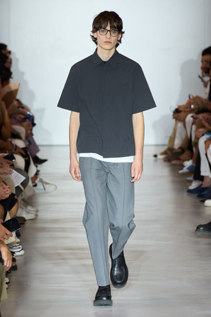 A relaxed gray short-sleeve collared shirt paired with black straight-leg pants.