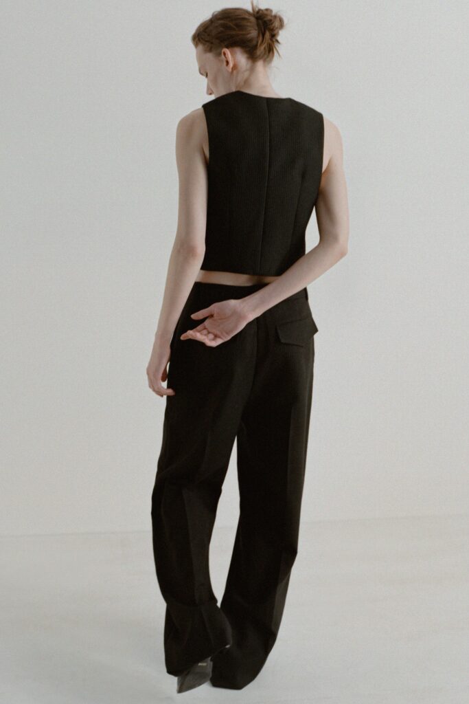 A fitted black sleeveless top paired with straight-leg pants for a sleek look.