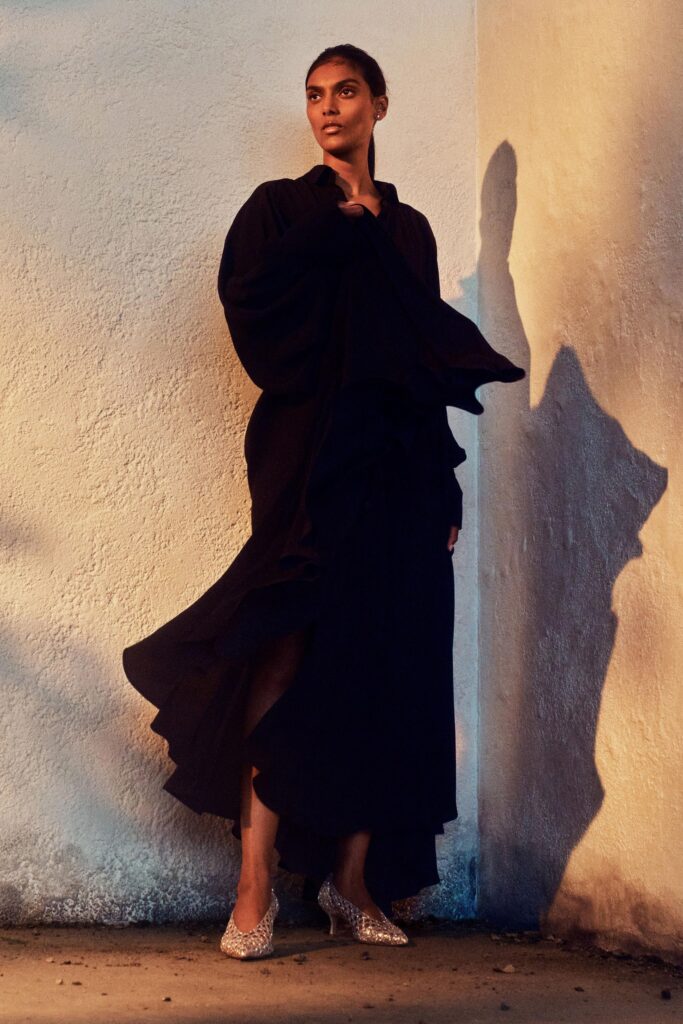 A relaxed black silk dress with long sleeves and an asymmetric layered design.
