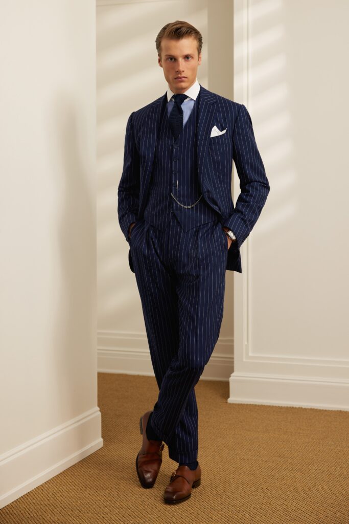 A tailored navy striped suit with long sleeves and a collared shirt.