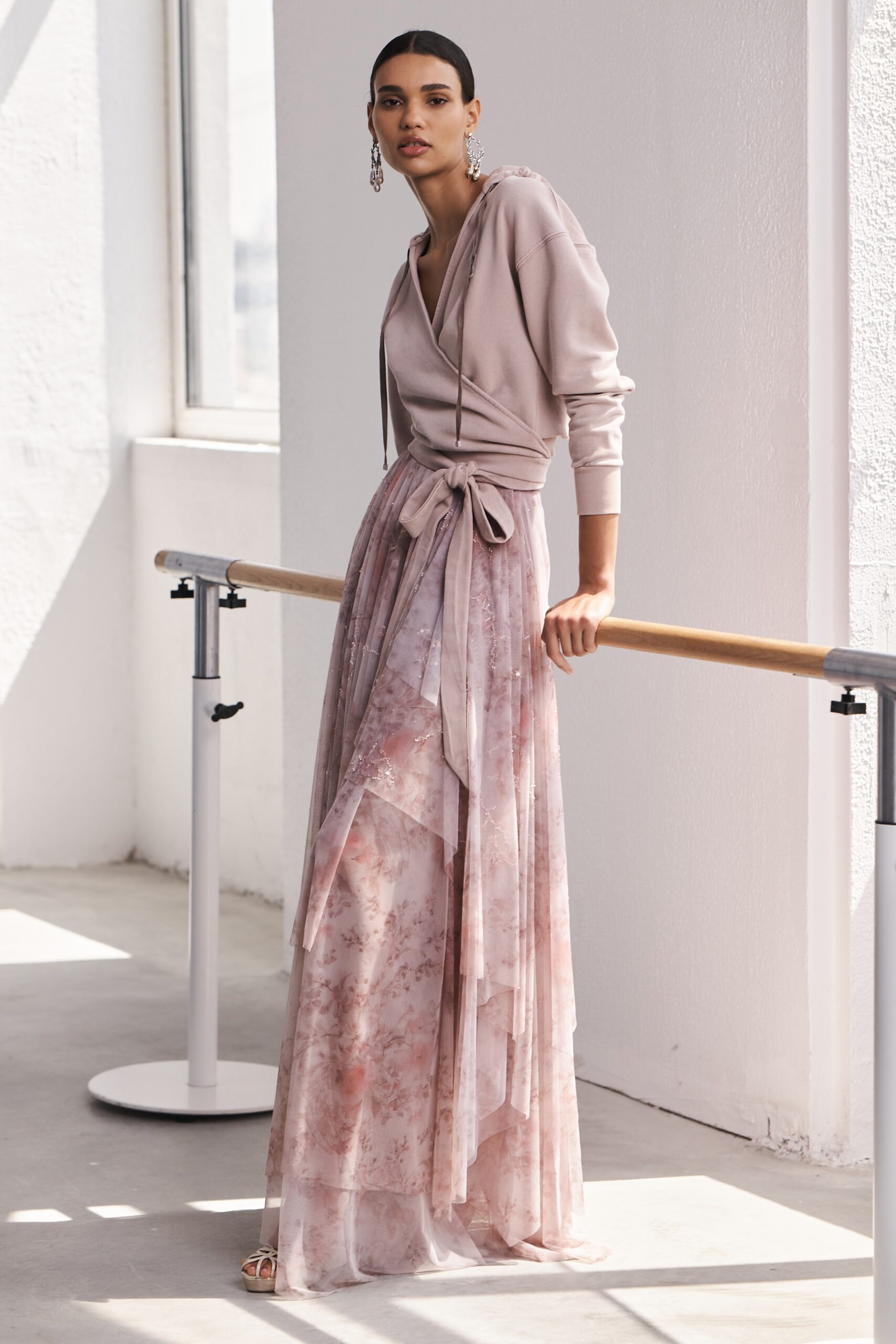 A relaxed pink silk dress with a long-sleeve V-neckline and layered design.