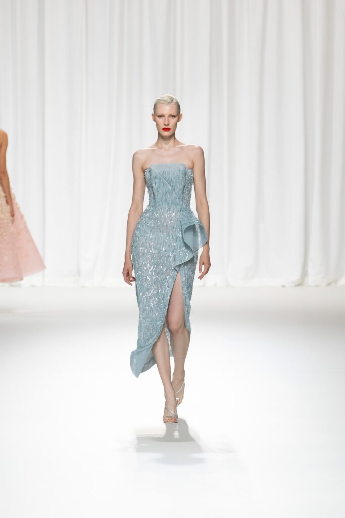 A fitted blue silk strapless dress featuring a dramatic slit for a striking silhouette.