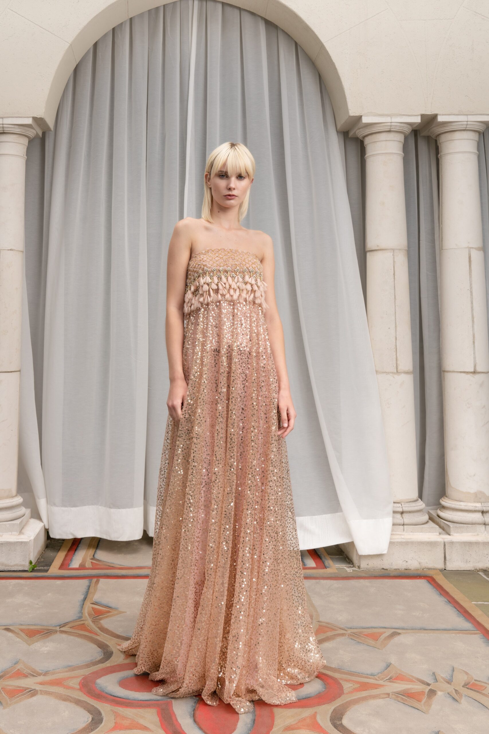 A fitted pink sequin strapless gown featuring a tiered design for an elegant look.