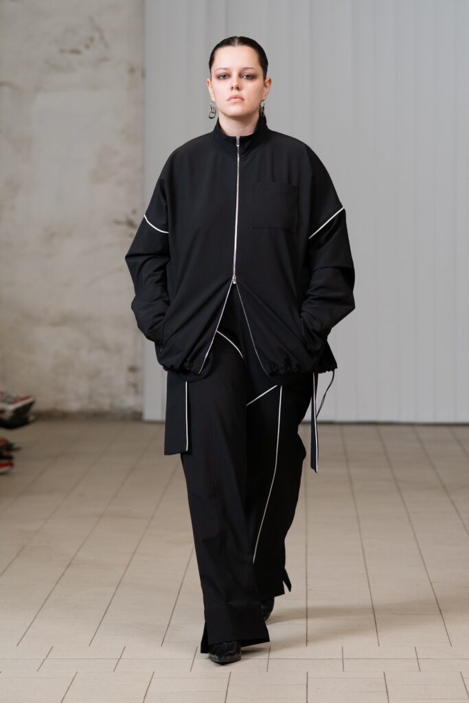 An oversized black jacket with zippered detail paired with matching black pants.