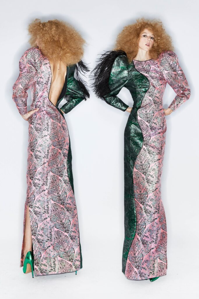 A fitted long-sleeve dress in pink and green with a V-neckline and asymmetric slit detail.