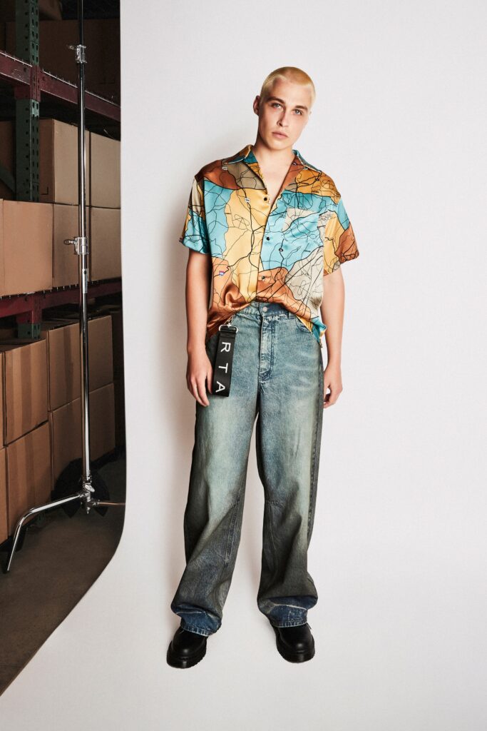 A relaxed-fit multicolor printed shirt paired with wide-leg denim jeans.