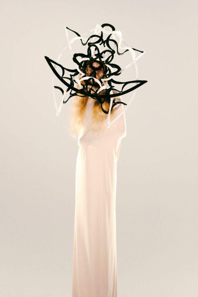 A longline white silk sleeveless dress featuring an avant-garde design.