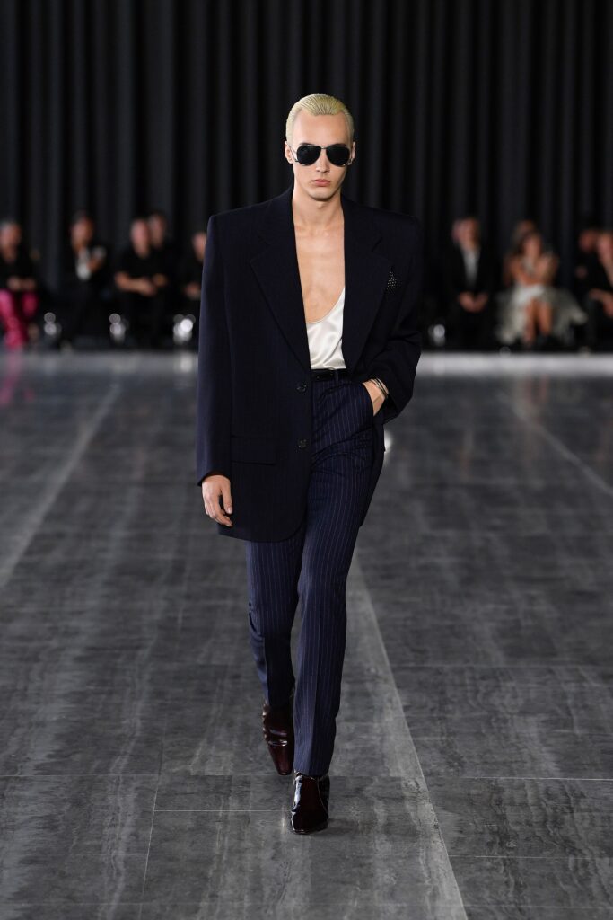 A tailored navy blazer with long sleeves and striped pants, creating a sophisticated look.