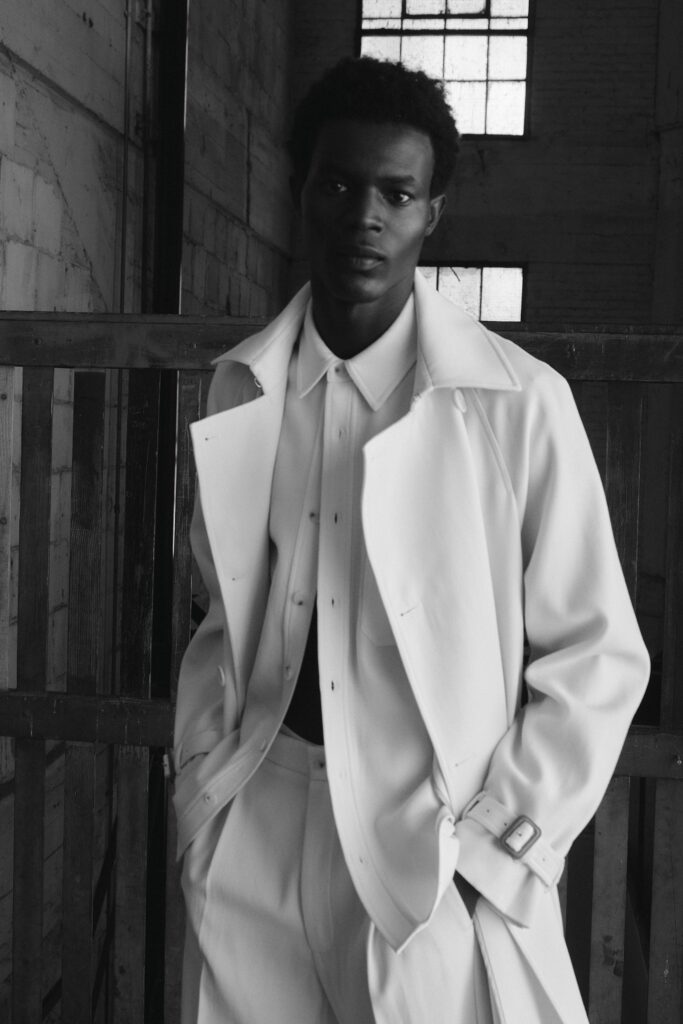 A fitted white coat paired with a collared long-sleeve shirt, showcasing a modern silhouette.