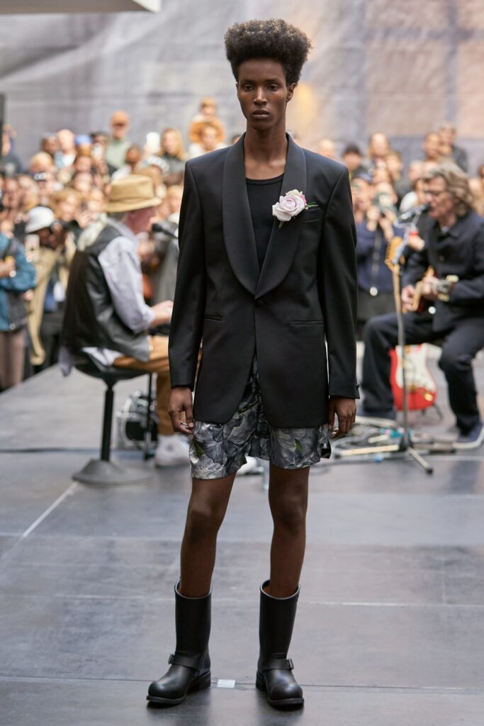 A fitted black blazer paired with multicolor printed shorts, featuring a collared design.