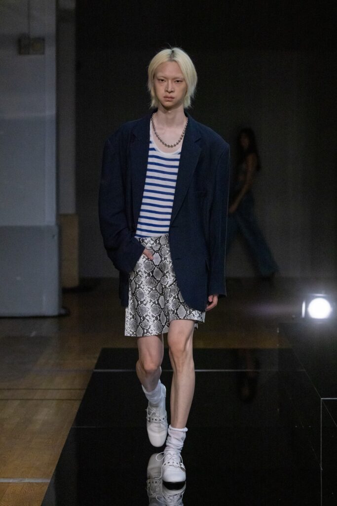 An oversized blue jacket paired with a printed skirt and striped top for a trendy look.