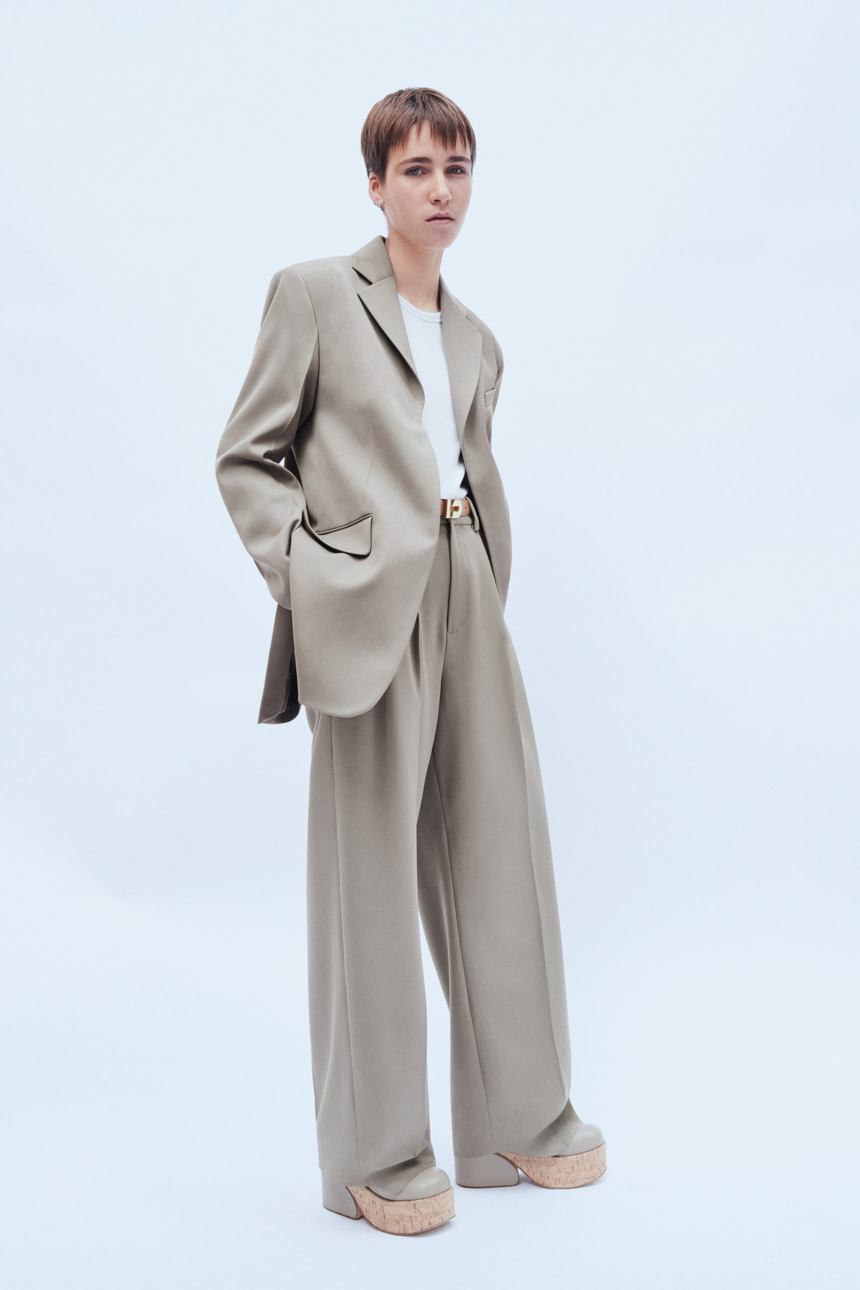 A relaxed beige suit with long sleeves and wide-leg trousers for a modern look.