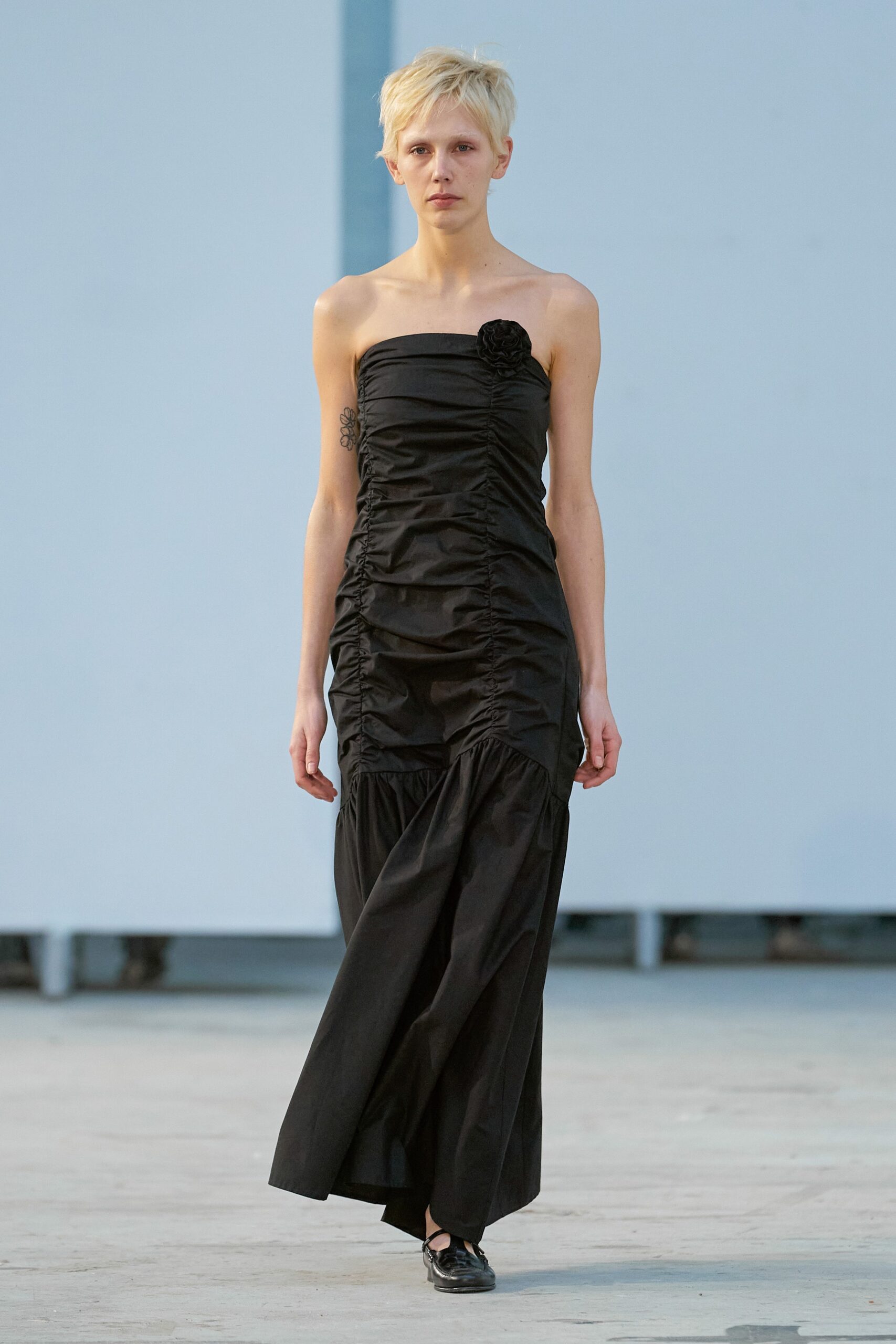 A fitted black strapless dress with ruched detailing for a stylish silhouette.