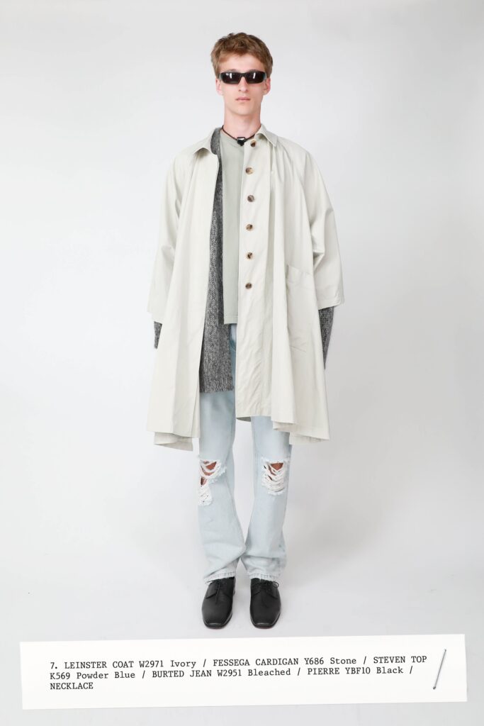 A relaxed ivory coat layered over a gray long-sleeve top, featuring a buttoned design.