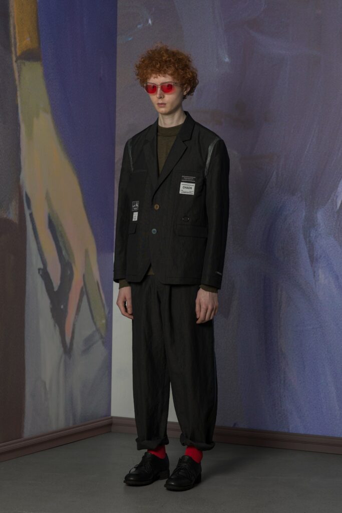 A relaxed black cotton jacket with long sleeves and collared design, paired with straight-leg pants.