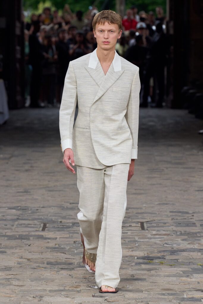 A tailored beige linen suit with a collared long-sleeve jacket and straight-leg pants.