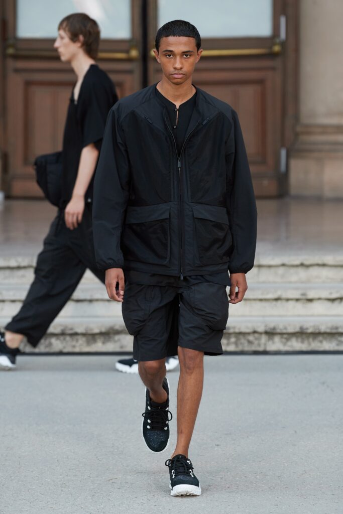 A relaxed black jacket with long sleeves and a collared design paired with matching shorts.