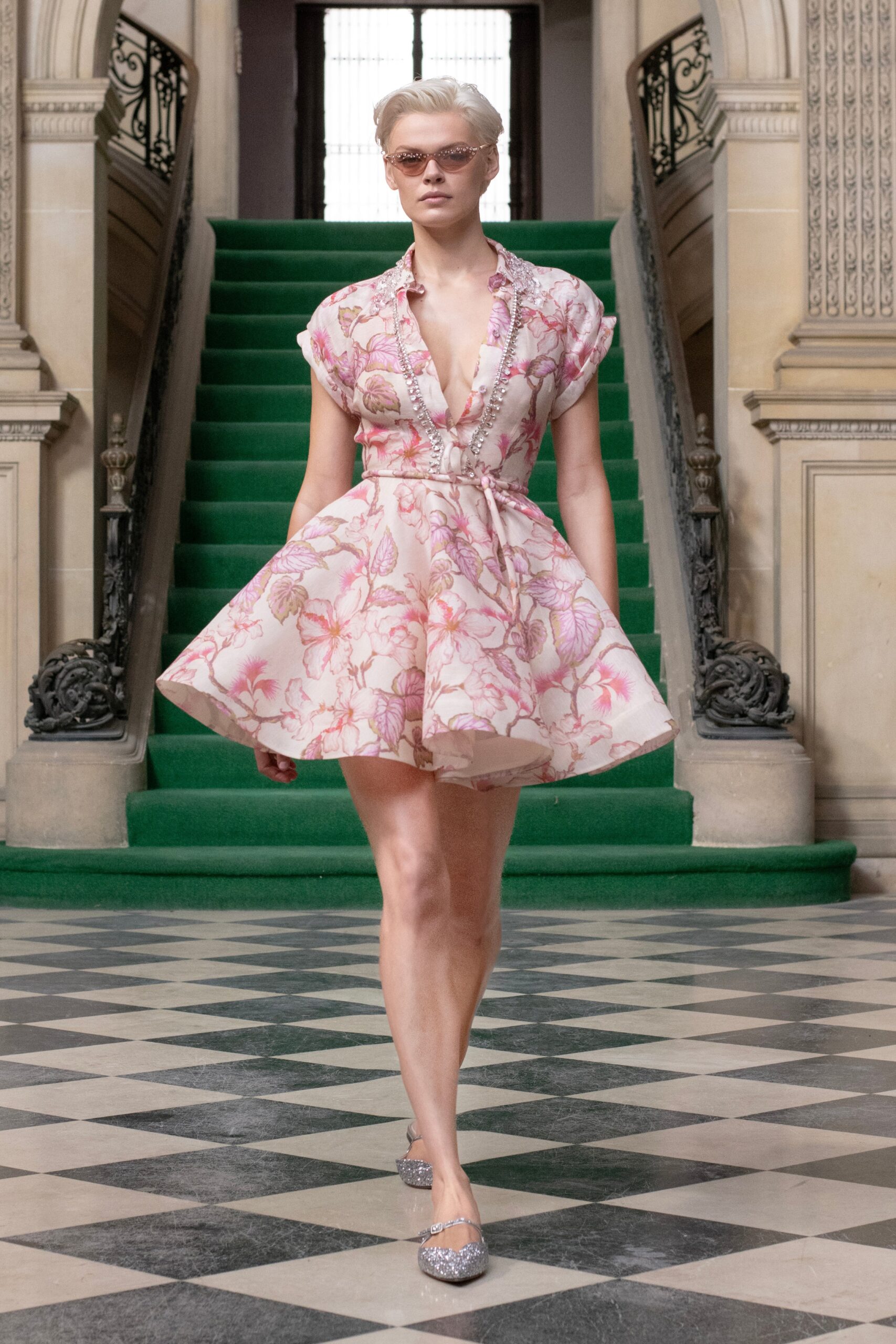 A fitted pink floral dress with short sleeves and a flared silhouette.