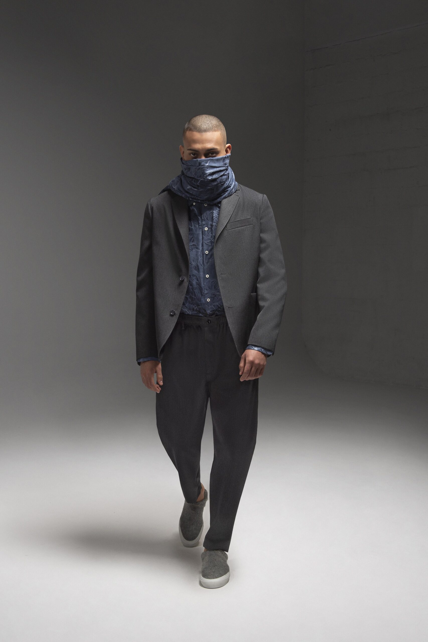 A relaxed black jacket paired with blue striped pants and a collared shirt.
