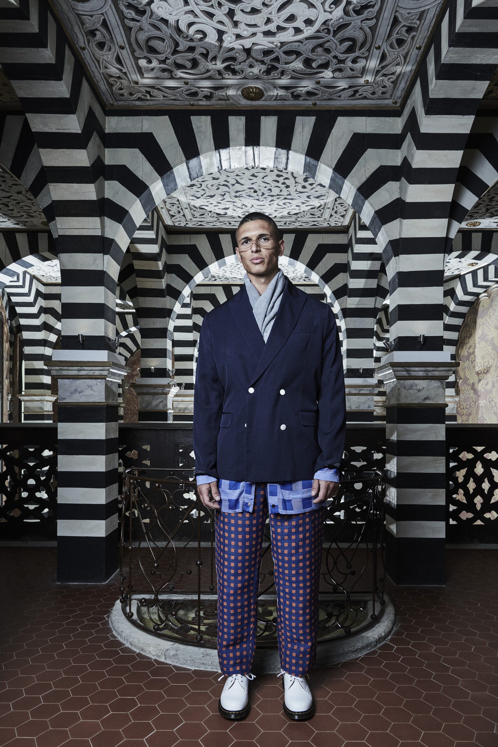 A relaxed blue jacket with a collared neckline paired with checked pants.