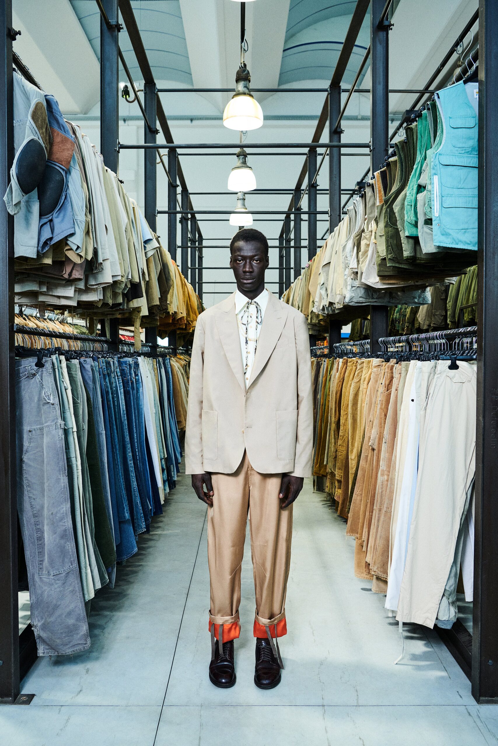 A tailored beige suit with a collared long-sleeve shirt and buttoned details.