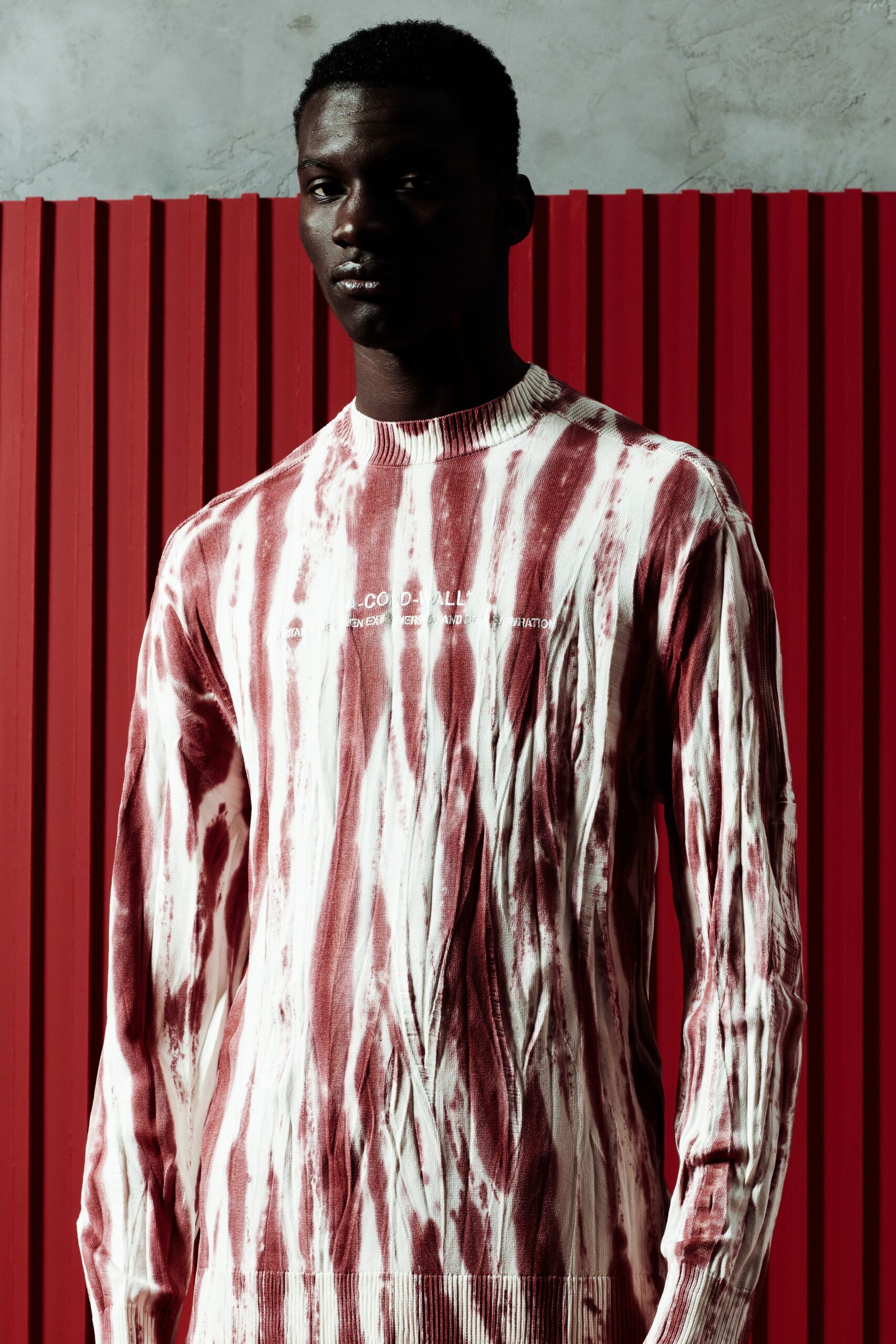 A fitted red and white striped sweater with long sleeves and a crew neckline.